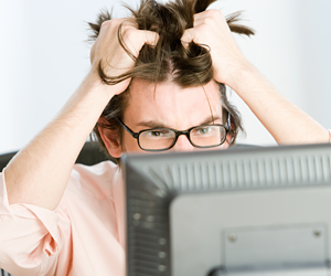Frustrated user pulling their hair while staring angrily at a computer screen