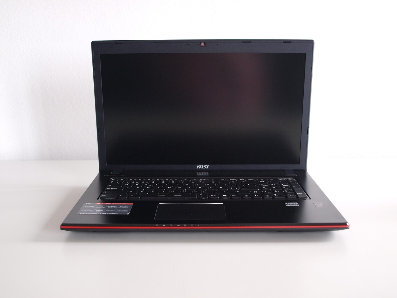 Black MSI laptop with red highlight coloring, opened and facing the viewer