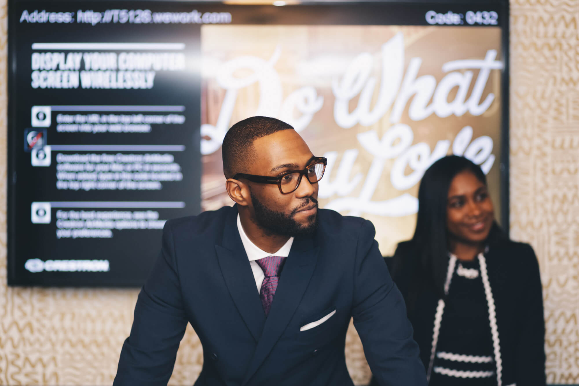 Business professional in blue suit with purple tie and horn-rimmed glasses