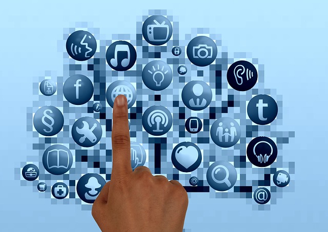 Finger pressing a pale blue touchscreen of icons against a pixelated background