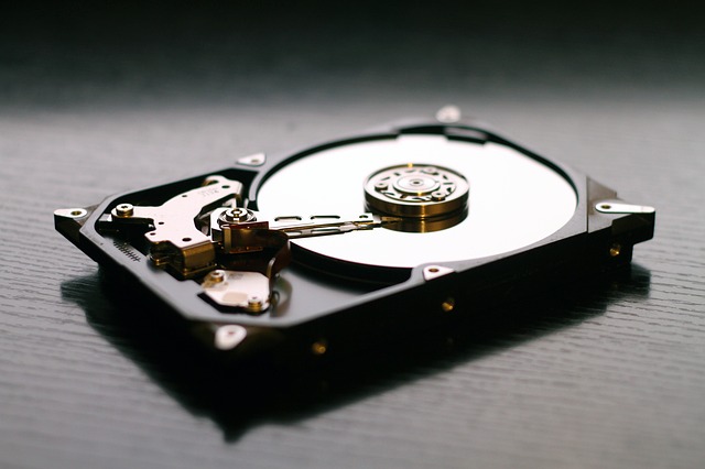 Open hard drive sitting on a table with its internals exposed