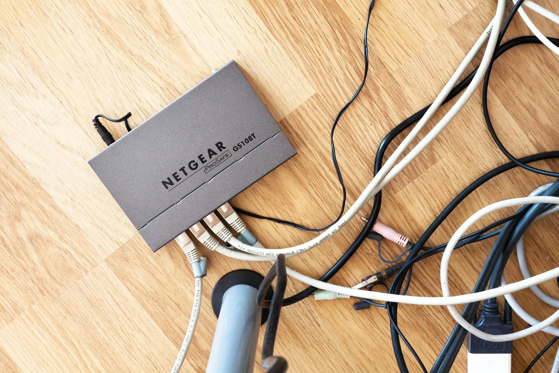 Netgear ProSafe GS108T router with 4 Ethernet cables plugged into it