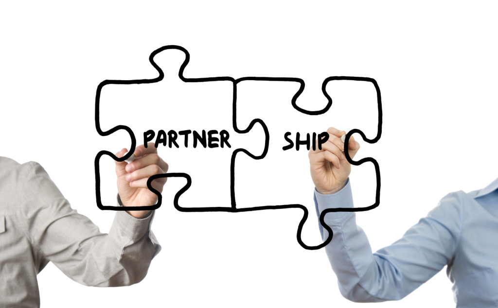 Two puzzle pieces being drawn in the air, one saying 'partner' and the other 'ship'