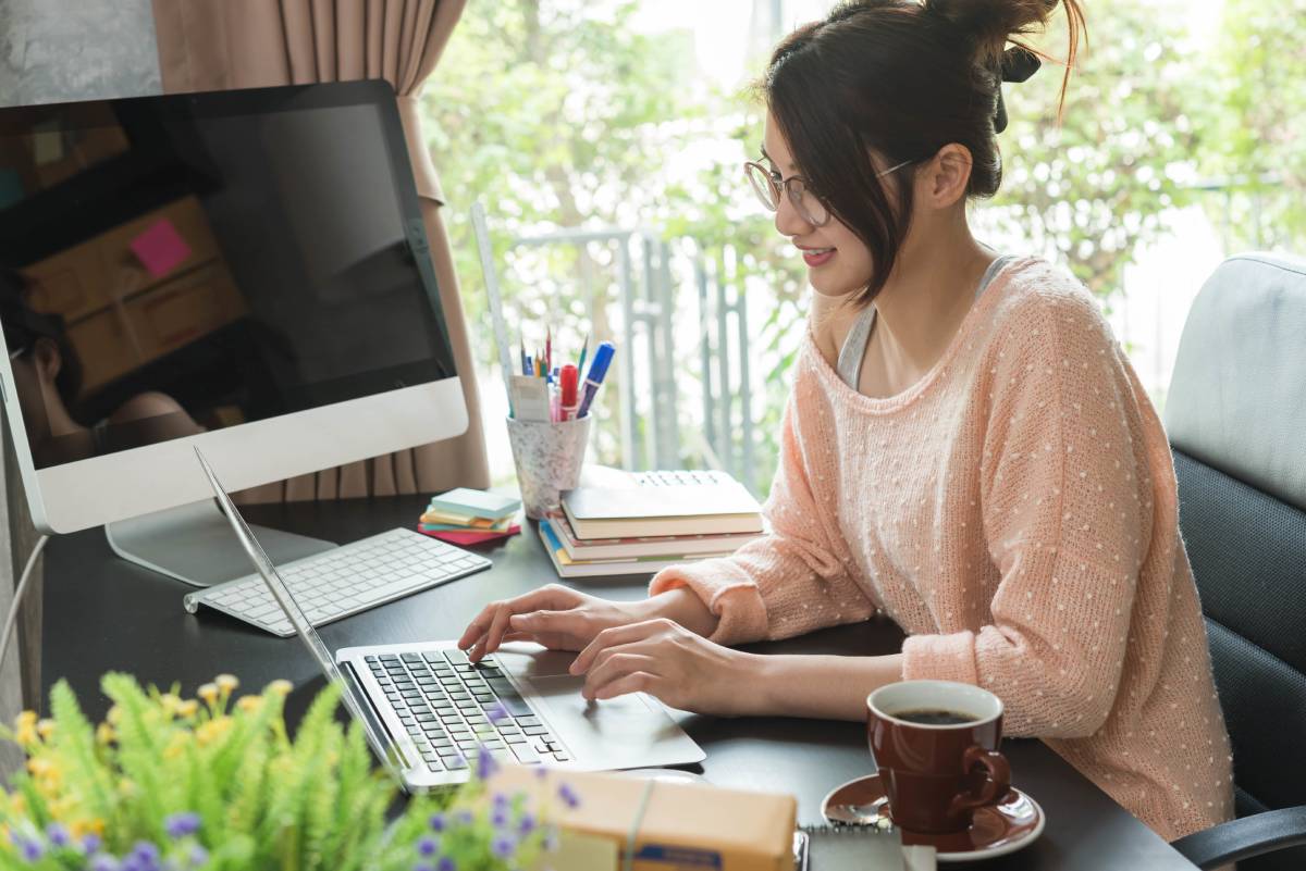 Woman working remotely in her home office with a laptop