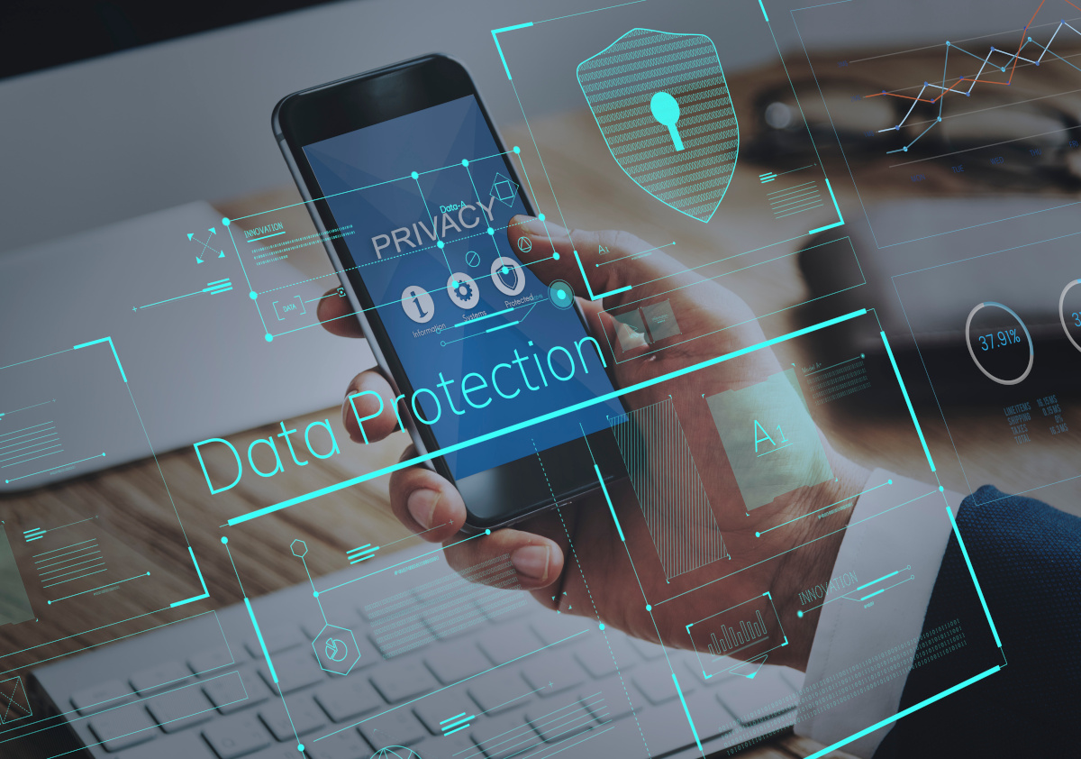 A businessman holding a phone with a graphical overlay in the foreground saying 'Data Protection'