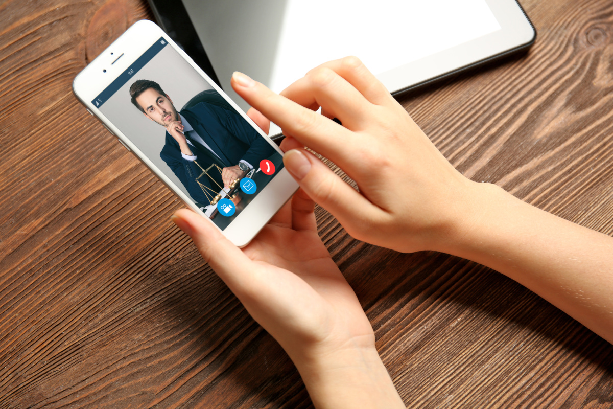 A woman using her phone to have a video conference with her colleague