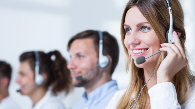 Row of Smiling Call Center Representatives on Light Background