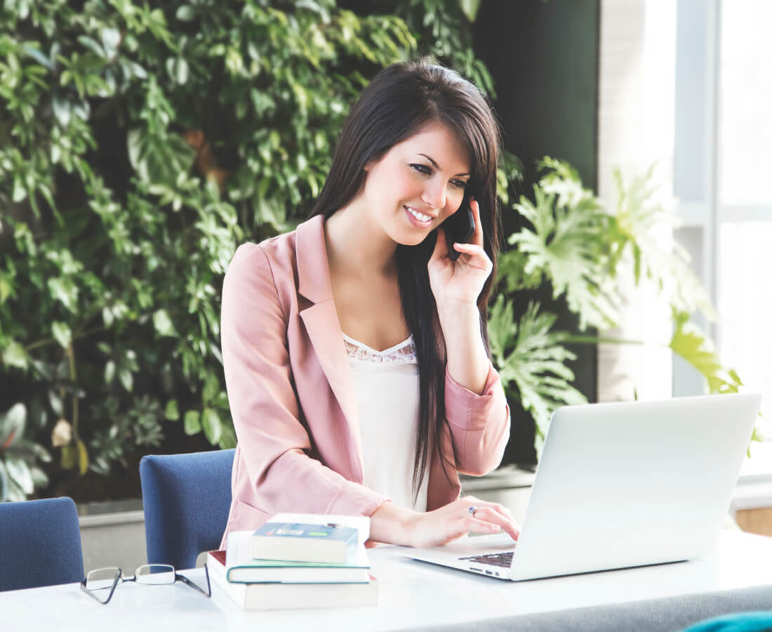 Smiling Businesswoman on Cell Phone Wearing Pink Jacket