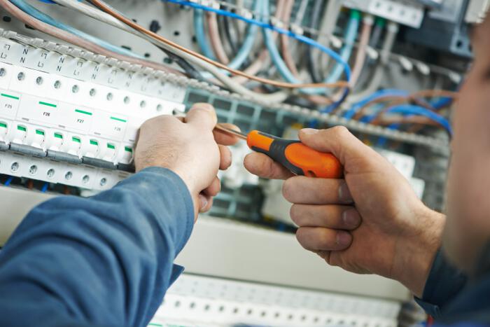 Close Up of Technician's Hands Holing Screwdriver Installing Network Cabling