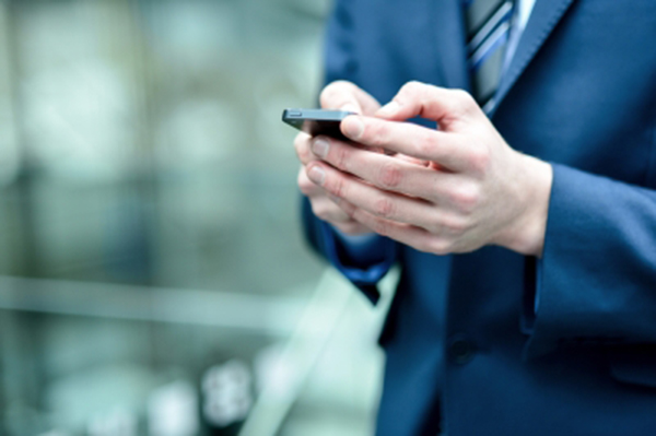 Close Up of Businessman's Hands in Blue Suit Dialing Cell Phone