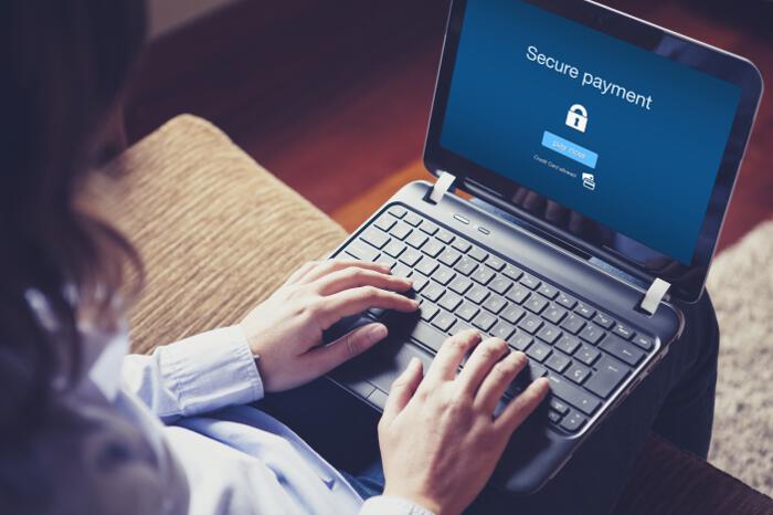 Woman in Front of Laptop with Secure Payment Message on Screen